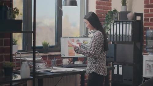 Woman Reviews Data in Brick Office