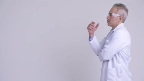 Profile View of Happy Persian Man Doctor Wearing Protective Glasses Thinking