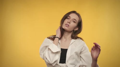 Stylish Woman Posing in Studio with Yellow Backdrop