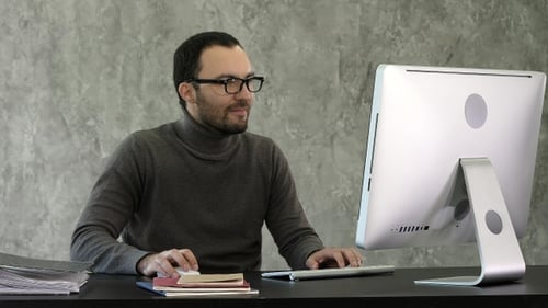 Business man sitting at desk in office and woking on the computer.