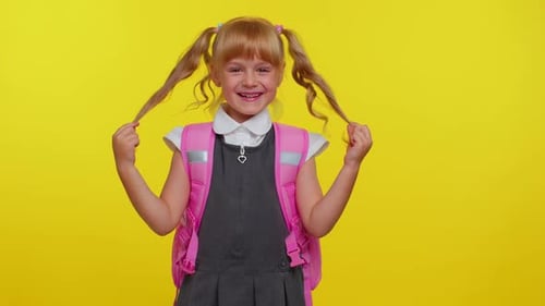 Happy Girl Kid in Schuluniform Spielen mit Pferdeschwänzen Lachen Herumalbern Verspieltes dummes Gesicht machen