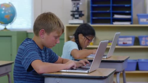 Students in school classroom working on laptop computers