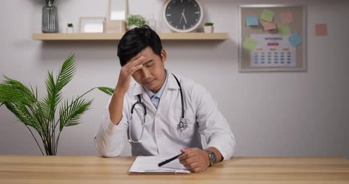 Doctor Reviewing Patient Notes at Desk