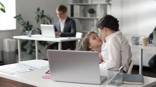 Business Lady Bonding mit kleinem Sohn am Schreibtisch