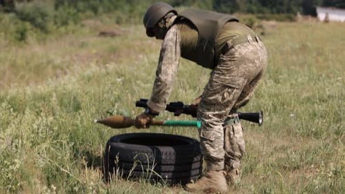 Soldier Prepares Rocket-Propelled Grenade Launcher in Field