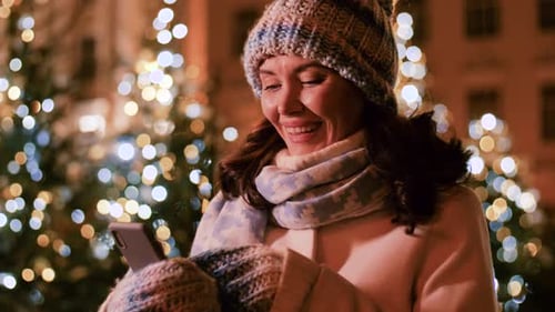 Happy Woman with Smartphone in Christmas City