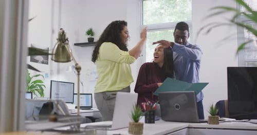 Happy diverse group of business people working together, discussing work in modern office