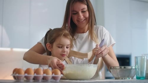 Woman and Child Cooking Together in Bright Kitchen