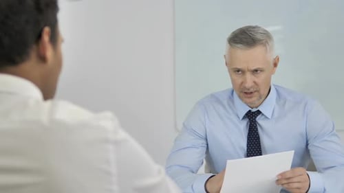 Businessmen Review Documents During Office Meeting
