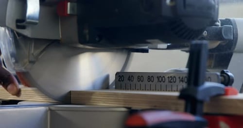 Carpenter cutting wooden plank with electric saw in workshop 4k