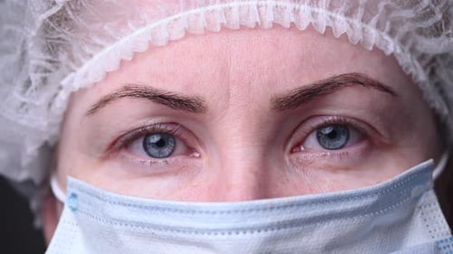 Visage d'un homme portant un masque médical. La docteure regarde la caméra. Combattre le virus Covid-19