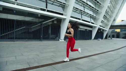 Woman Running Towards Fitness Near Stadium