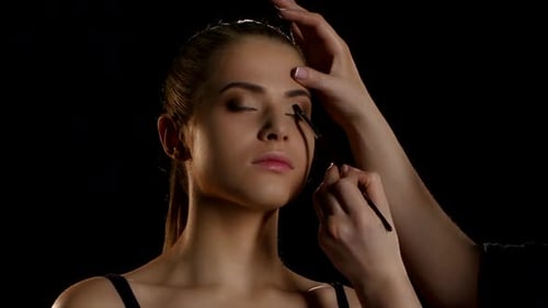 Professional Make-up Artist Feathering Light Eyeshadow on the Eyelid. Close-up