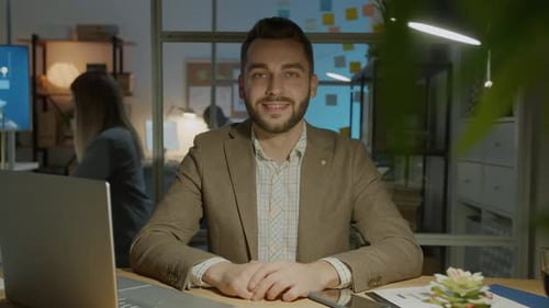 Slow Motion Portrait of Happy Young Entrepreneur Sitting in Office in the Evening Smiling