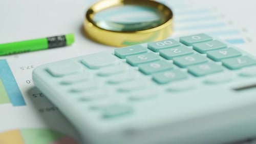 Documents with Magnifying Glass and Calculator