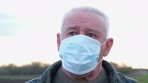 Adult With Gray Hair Wearing Medical Mask Outdoors