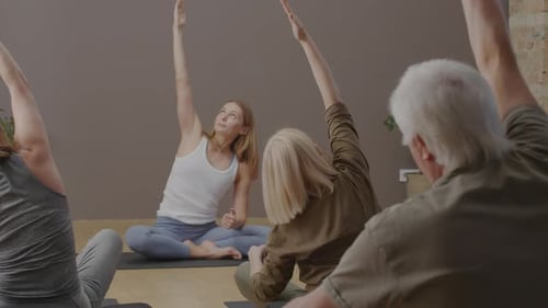 Stretching with Instructor in Yoga Studio