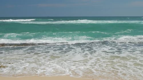 Sea Waves Roll on Tropical Beach Under Blue Sky Slow Motion
