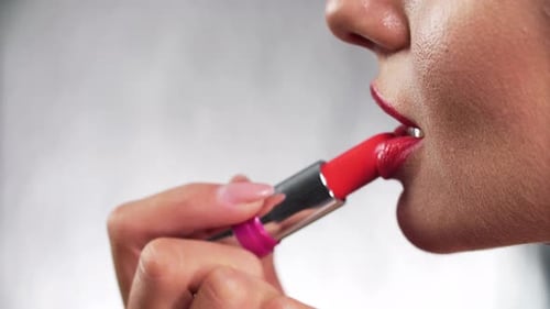 Woman Applying Bright Red Lipstick, Close Up