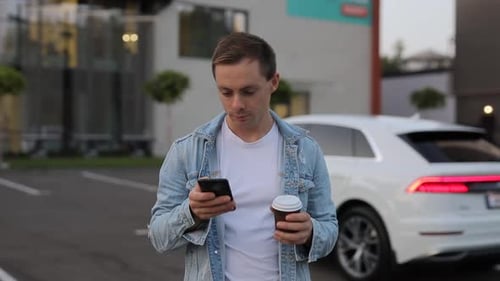 Man Drinking Coffee in City Using Smartphone