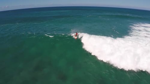 Aerial view of a man sup stand-up paddleboard surfing in Hawaii
