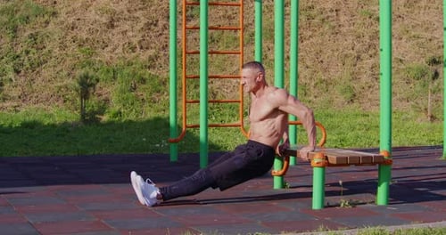 Muscular Man Doing Dips in Outdoor Park