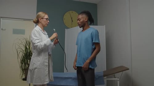 Doctor Examining Young Adult Man with Stethoscope