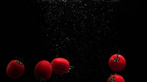 Red Ripe Tomatoes Falling In Water With Air Bubbles Splash And Droplets