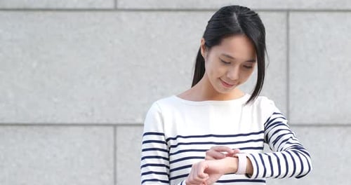 Young Woman Using Smartwatch in City