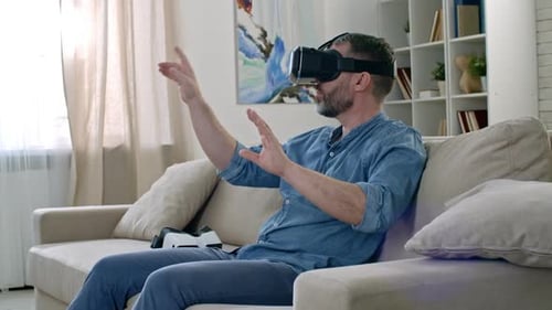 Man Uses Virtual Reality Headset at Home