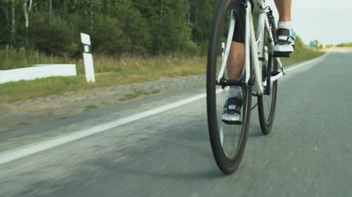 Sporty Woman in Helmet Riding Bicycle on Road