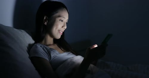 Uso femenino del teléfono móvil en la cama