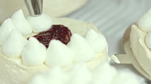 Creamy White Cake Being Prepared in a Kitchen