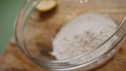 Gloved Hand Adds Flour to a Bowl