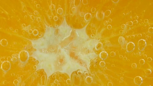 Luftblasen um eine Orangenscheibe.