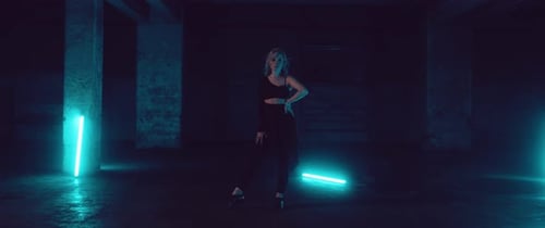Female Dancer in a dark Parking Lot with Neon Lights