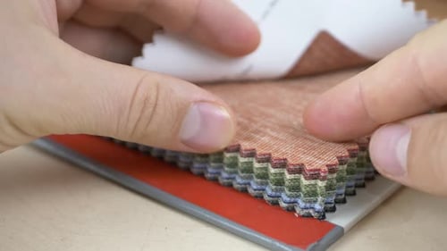 Close Up of Hands Browsing Fabric Swatch Book