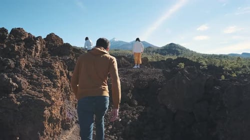 Eine Gruppe von Touristen wandert durch die Berge erstarrter Lava im Teide-Vulkan-Nationalpark