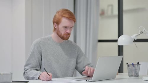 Focused Adult Working at Desk with Laptop
