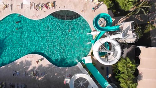 Fliegen Sie über einen großen Pool mit blauem Wasser und vielen Touristen bei heißem Wetter