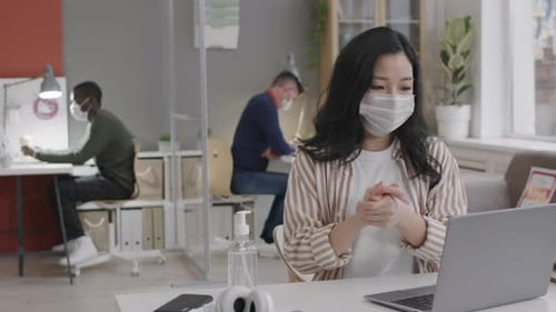 Asian Girl Using Sanitizer in Office