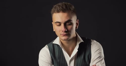 Man Smiles and Laughs in Dark Studio