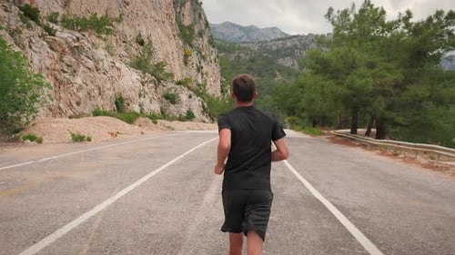 Plan de
suivi arrière d'un homme qui court dans la forêt.