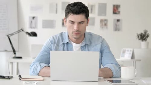Man Working on Laptop at Bright Office Desk