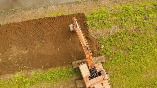 Excavator Digging a Trench in the Field