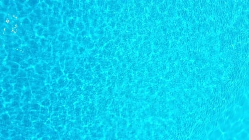 Blue Water in the Swimming Pool with Light Reflections