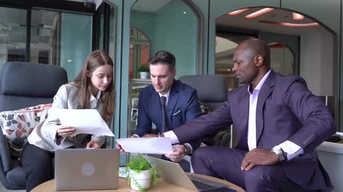 Young Black Man Giving Business Presentation to Team at Office Meeting