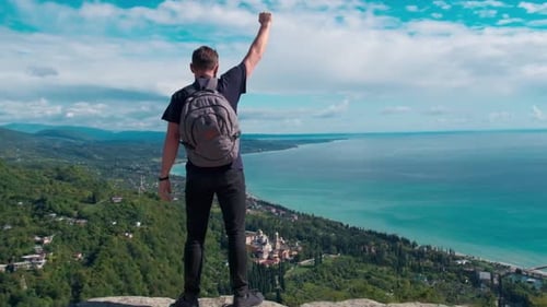 Adventure, Travel, Tourism, Hike and People Concept - Hiking Man with Backpack Looking at Sea or