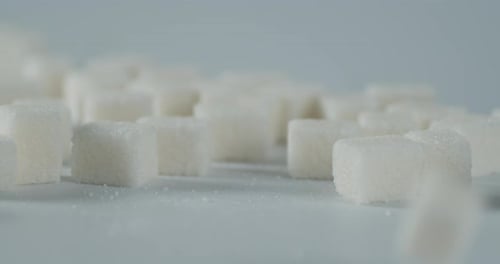 Zuckerwürfel fallen auf den Tisch