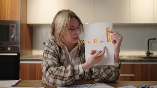 Young Woman Presents Business Charts in Kitchen